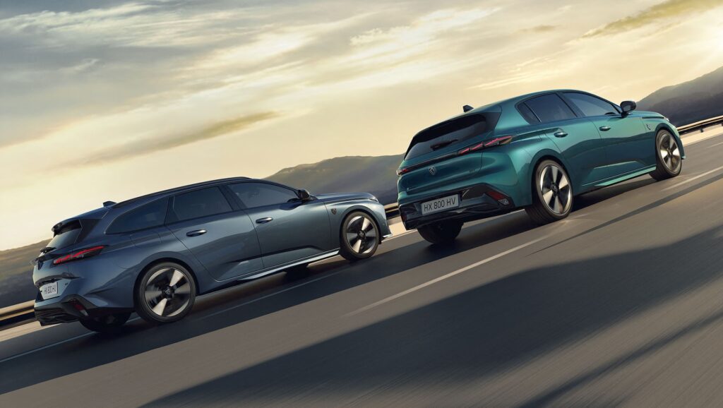 Zwei moderne Peugeot-Autos, ein blauer Kombi und ein grüner Schrägheckwagen, fahren auf einer Straße mit Bergen und einem hellen, bewölkten Himmel im Hintergrund.