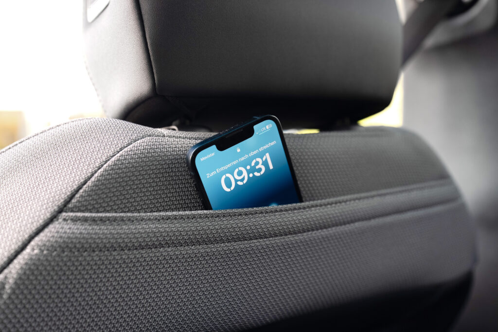 Smartphone steckt in der Rückentasche eines Vordersitzes im Innenraum des Opel Grandland.