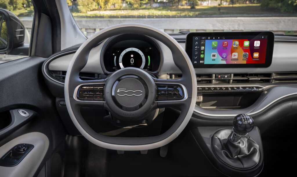 Innenraum des Fiat 500 Hybrid mit Multifunktionslenkrad, digitalem Kombiinstrument und zentralem Infotainmentsystem.